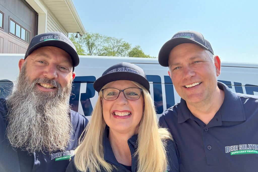 The friendly Deer Solution repellent service team smiling in front of a company service van.